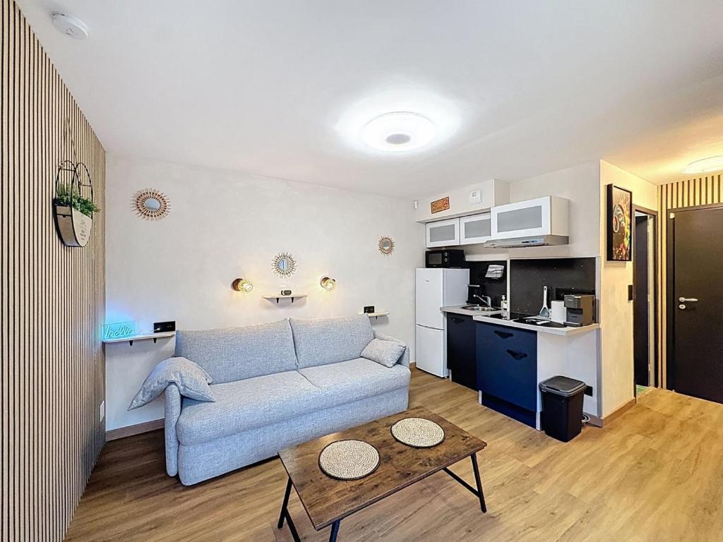 a living room with a couch and a kitchen at Studio avec terrasse in Amiens