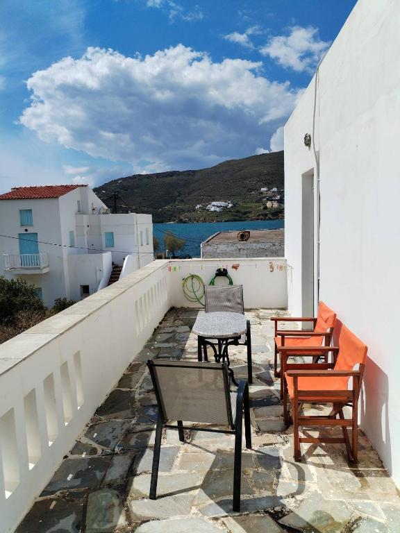 a balcony with chairs and a table on a building at Takis House in Gavrio