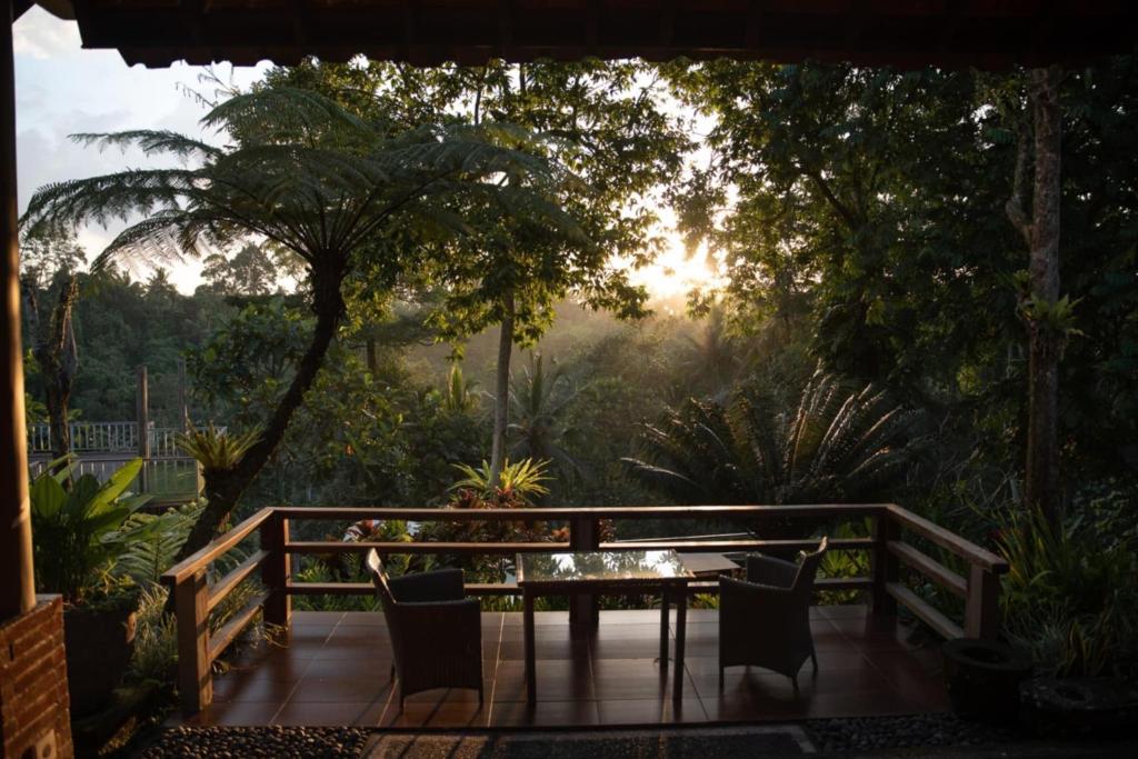 a patio with a table and chairs on a deck at Angsoka Bungalow in Ubud