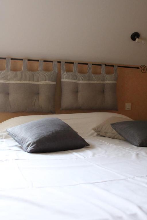 a large white bed with two pillows on it at La Table de Gabin in Saint-Léonard