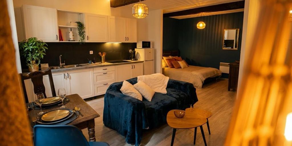 a living room with a couch and a kitchen at Appartement Ubac - Chic & Douillet in Saint-Gaudens
