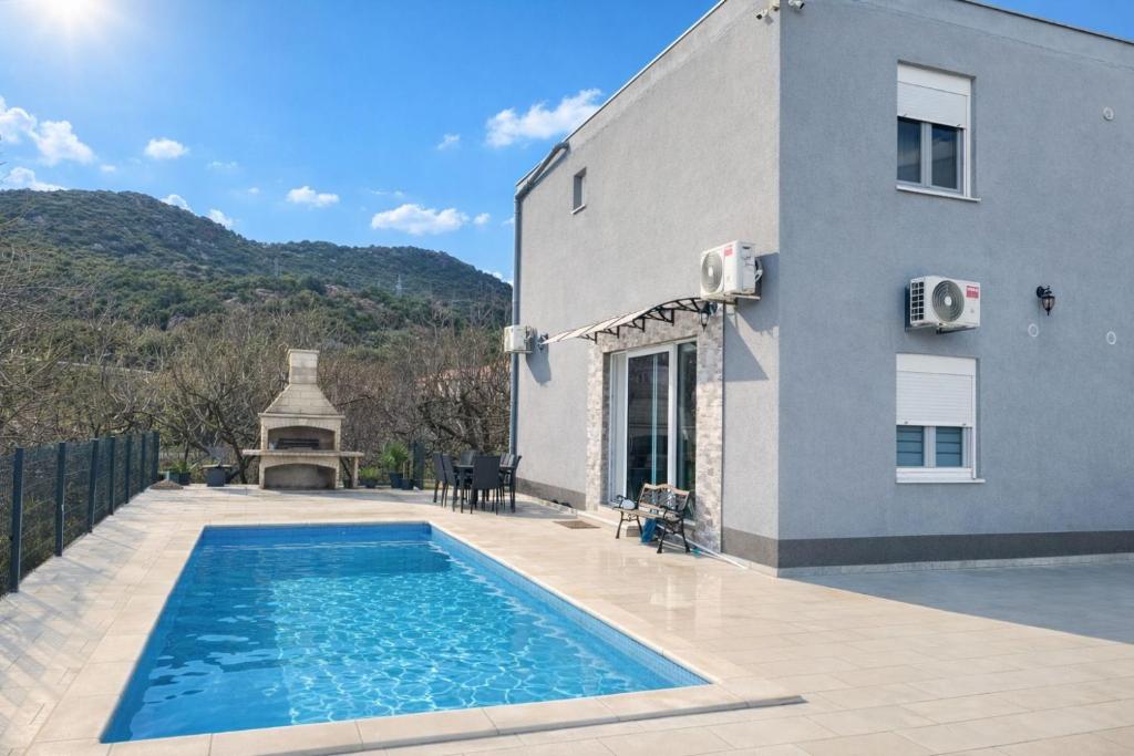 a swimming pool in front of a house at Apartment Ćulum in Peračko Blato