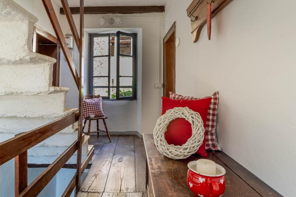 a room with a red pillow and a wooden floor at Bnbook Ca Du Val in Falmenta