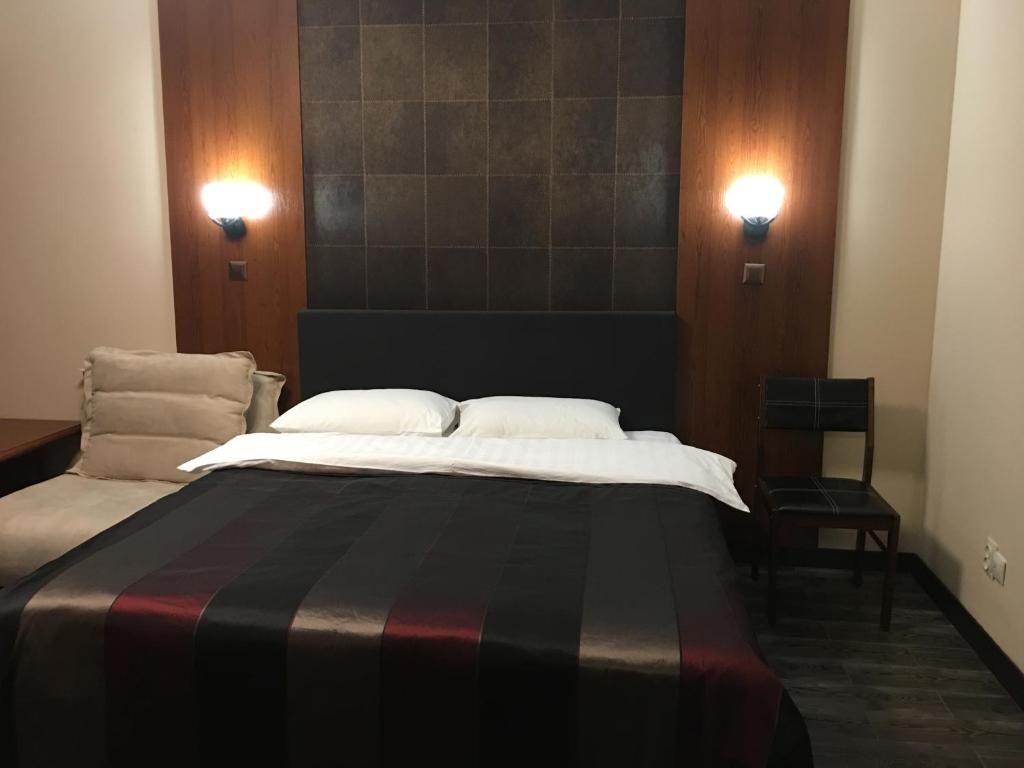 a bedroom with a large bed with two pillows at Alexandra Apartments in Kyiv