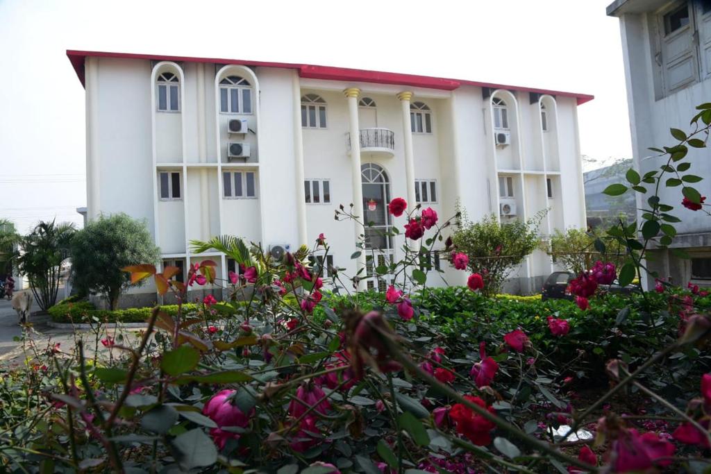 a building with pink roses in front of it at Hotel Royal Maithan International in Garphalbāri