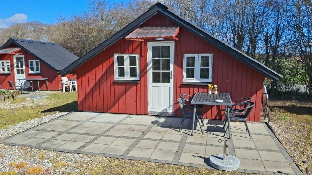 a red shed with a table in front of it at Tåsingecamping og Grill in Svendborg