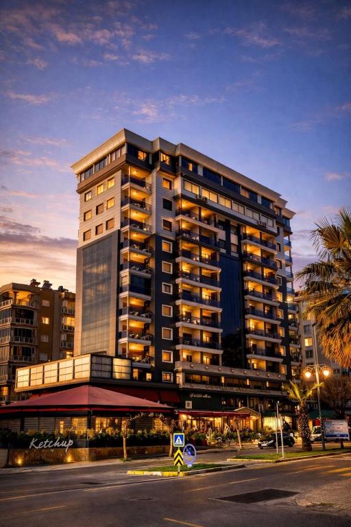 a tall building with lights on in a city at Lion Park Suites & Residence Hotel in Aydın
