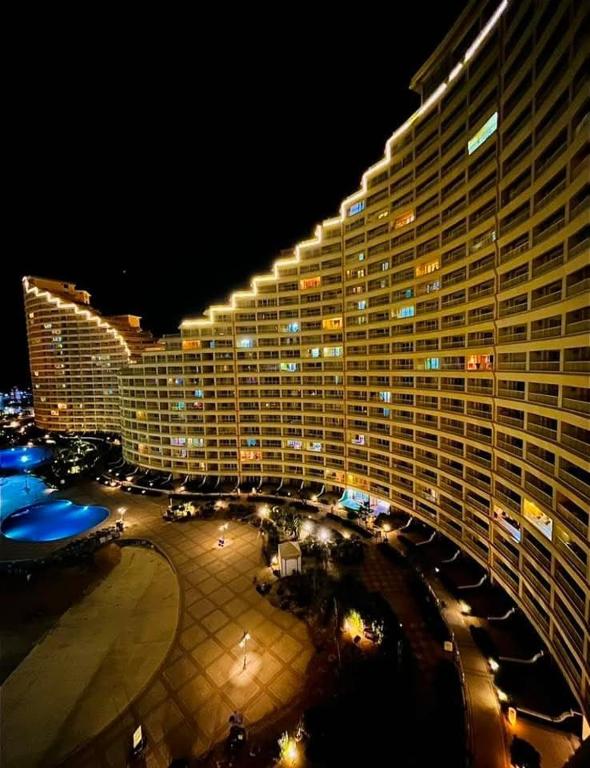 a large hotel building with a parking lot at night at Porto Sokhna Pyramids - For Families Only vip in Ain Sokhna