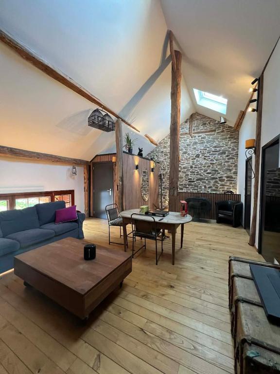 a living room with a couch and a table at La grange de Tom in Marche-en-Famenne