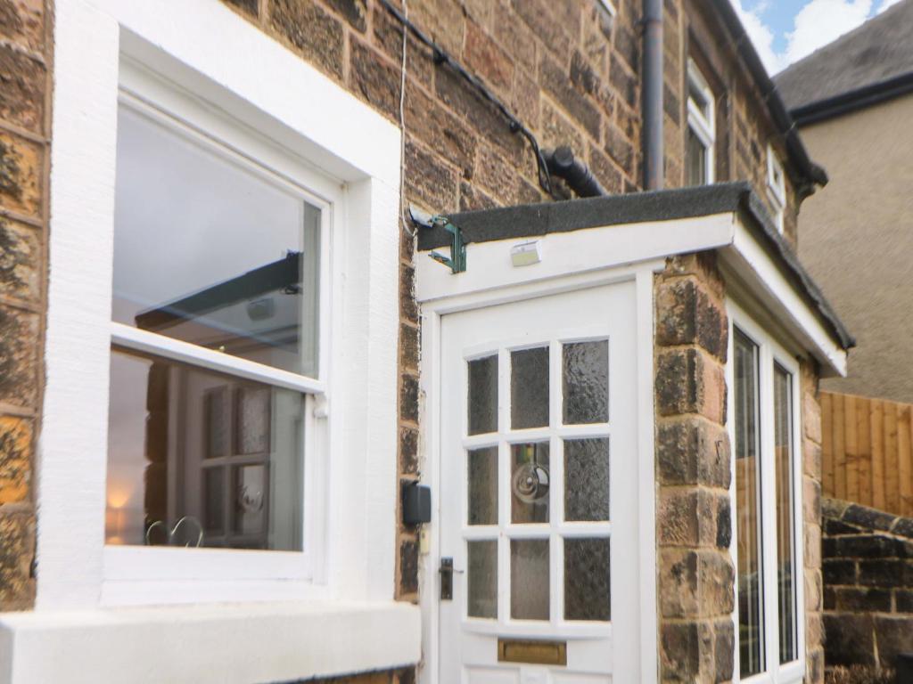 a door and window on a brick building at Natures Retreat in Matlock