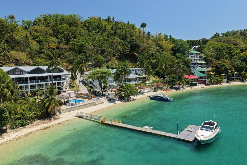 a boat is docked at a dock on a beach at Iluka 2- By the Bay in Puerto Galera