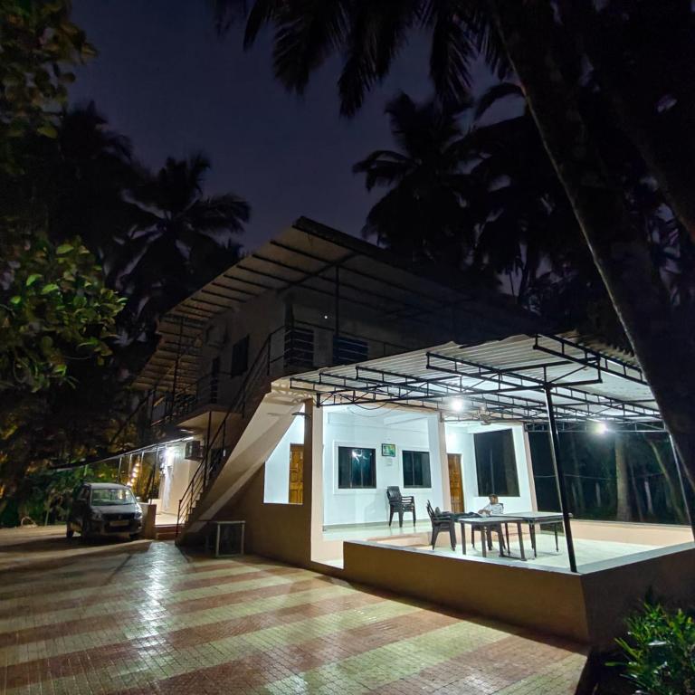a small house with a table outside at night at Shraddha Cottage in Nagaon
