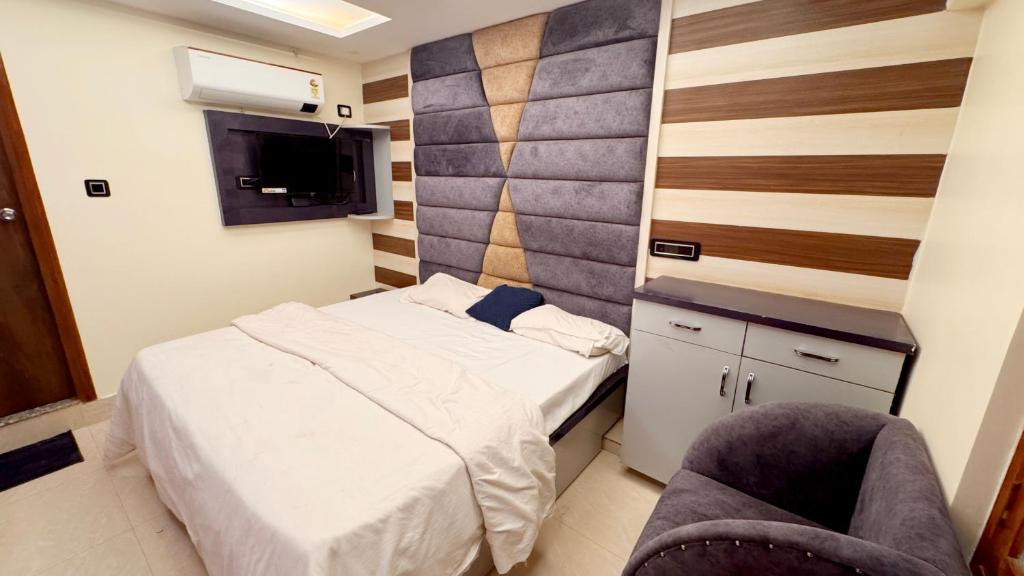 a small bedroom with a bed and a chair at Pragati Guest House in Gorakhpur