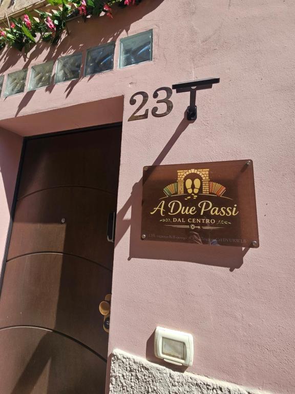 a sign on the side of a building with a door at B&B A due passi dal centro in Castelfidardo
