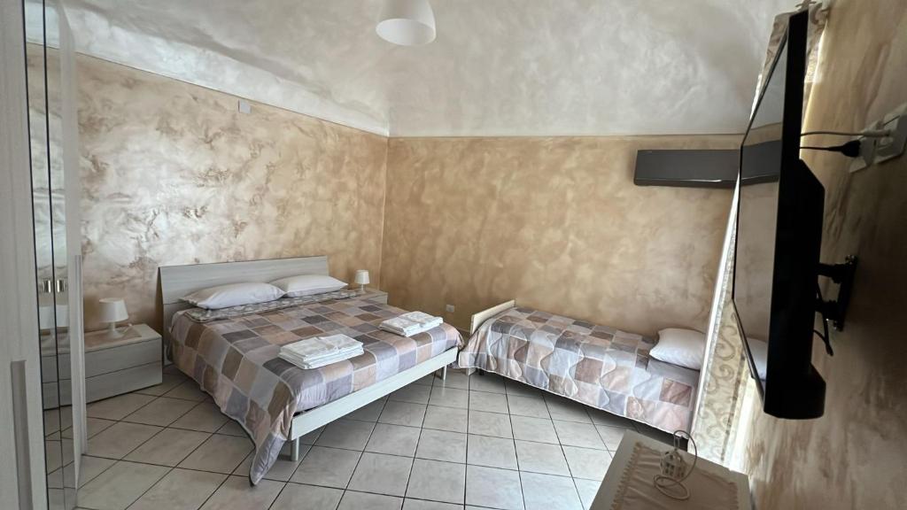 a bedroom with two beds and a glass shower at Agherè in Agira