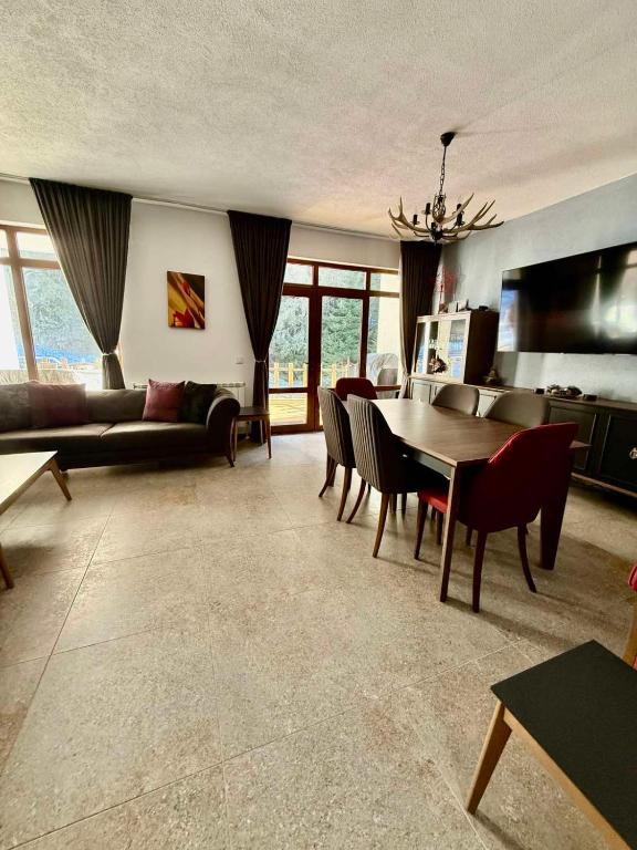 a large living room with a table and chairs at Вила Планински перли, Дом 11 in Stoykite