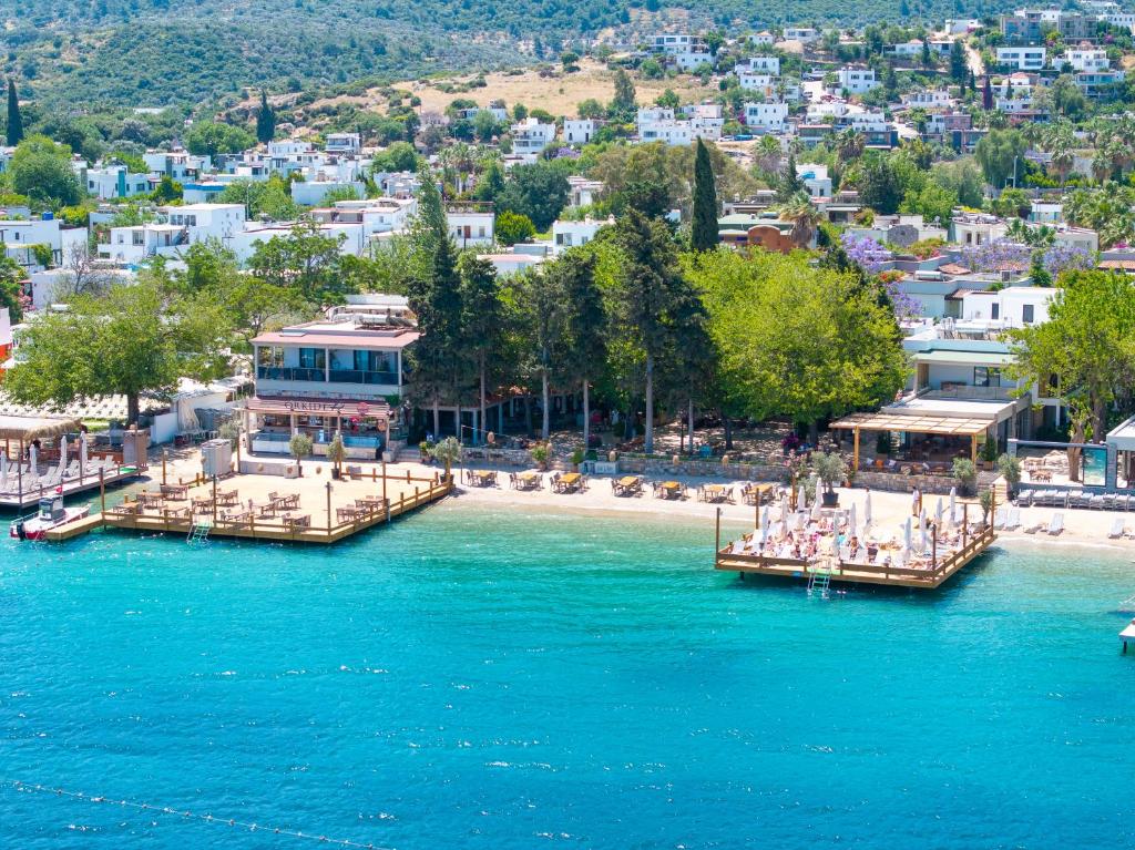 two boats in a body of water with a beach at Orkide Bodrum in Bodrum City