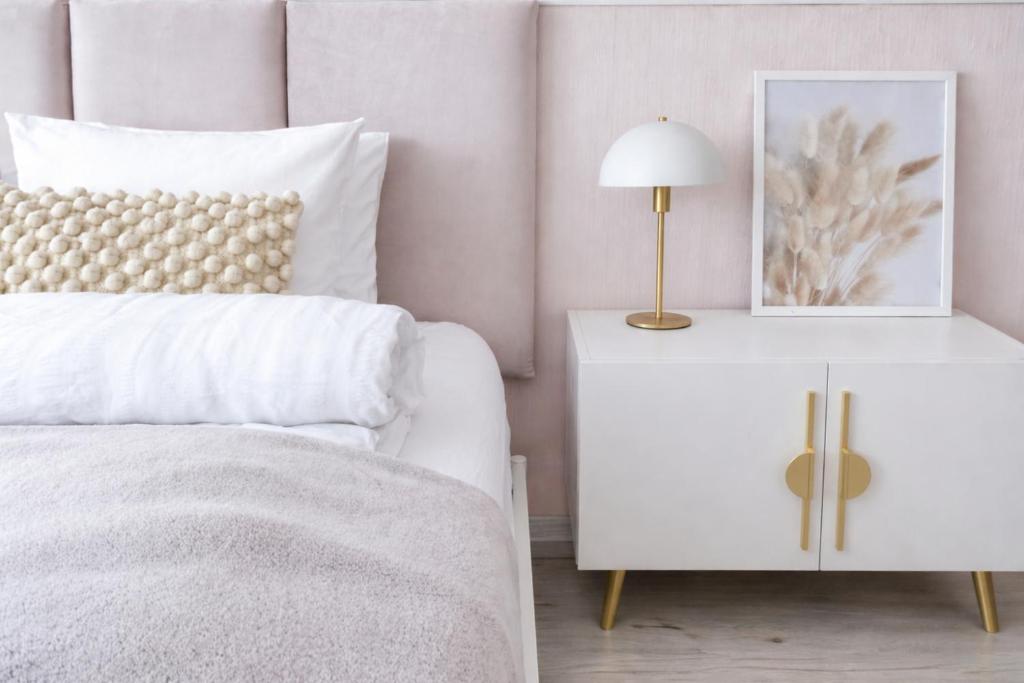 a bedroom with a white bed and a table with a lamp at Iris Home in Székesfehérvár