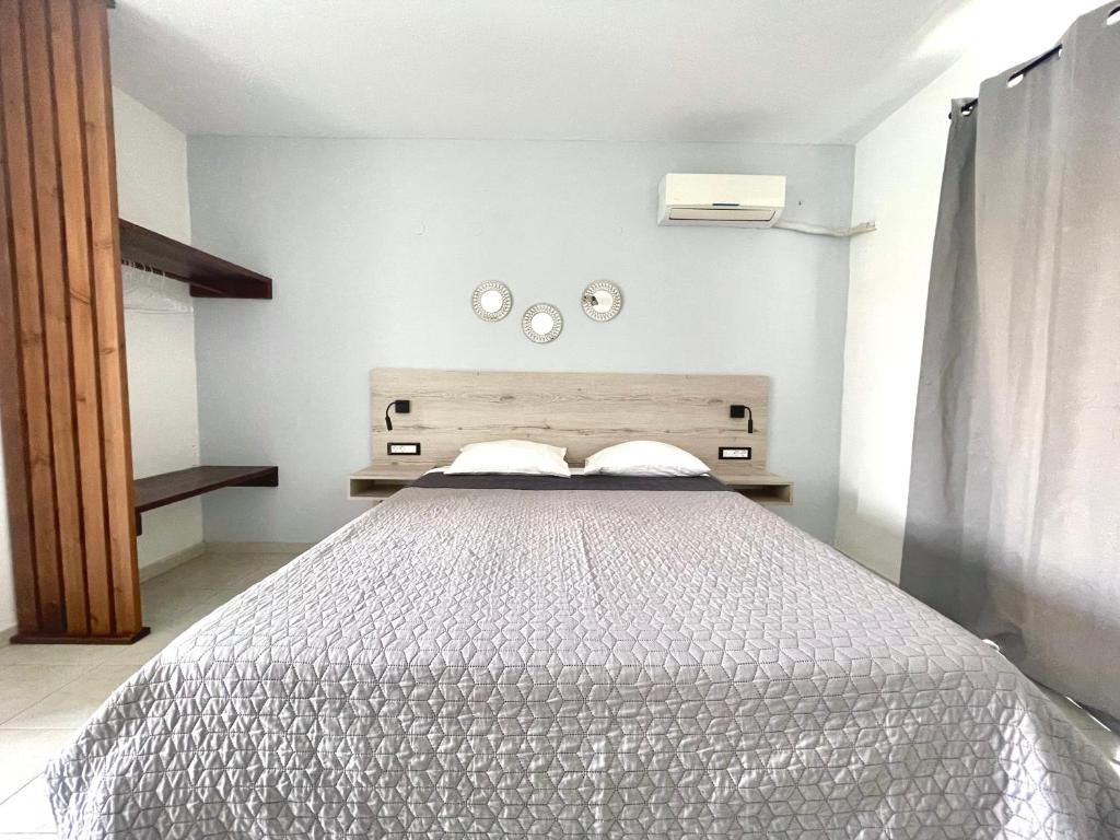 a bedroom with a bed and two mirrors on the wall at Dodekanisos Studios in Faliraki