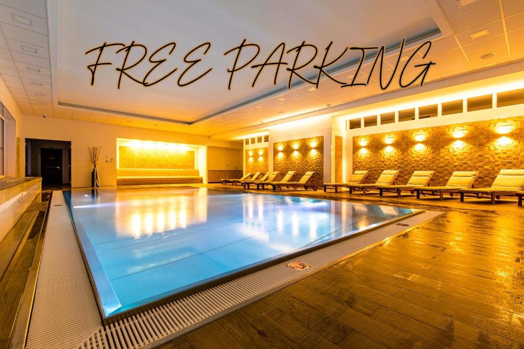 a swimming pool in a building with a sign that reads free parking at Rezidence Moser Apartments in Karlovy Vary