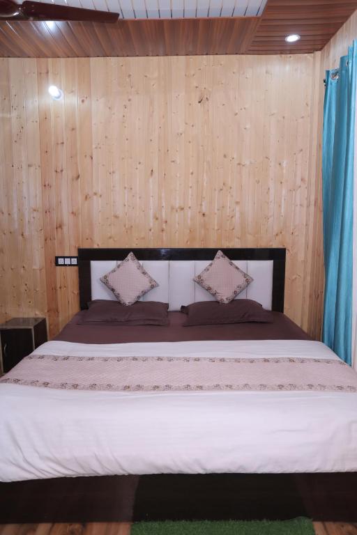 a bedroom with a bed with a wooden wall at Brahamkamal Resort in Gupta Kāshi