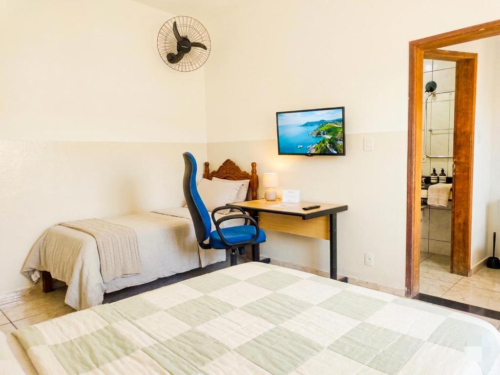 a bedroom with a bed and a desk with a chair at Casa Inteira Com Total Privacidade e Quintal in Pará de Minas