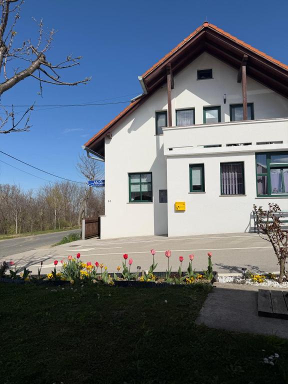 a white house with flowers in front of it at APARTMAN i SOBA HADELA in Sveti Martin na Muri