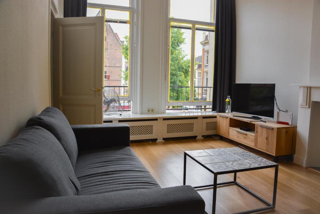 a living room with a couch and a tv at Hotel Nieuwe Markt in Deventer
