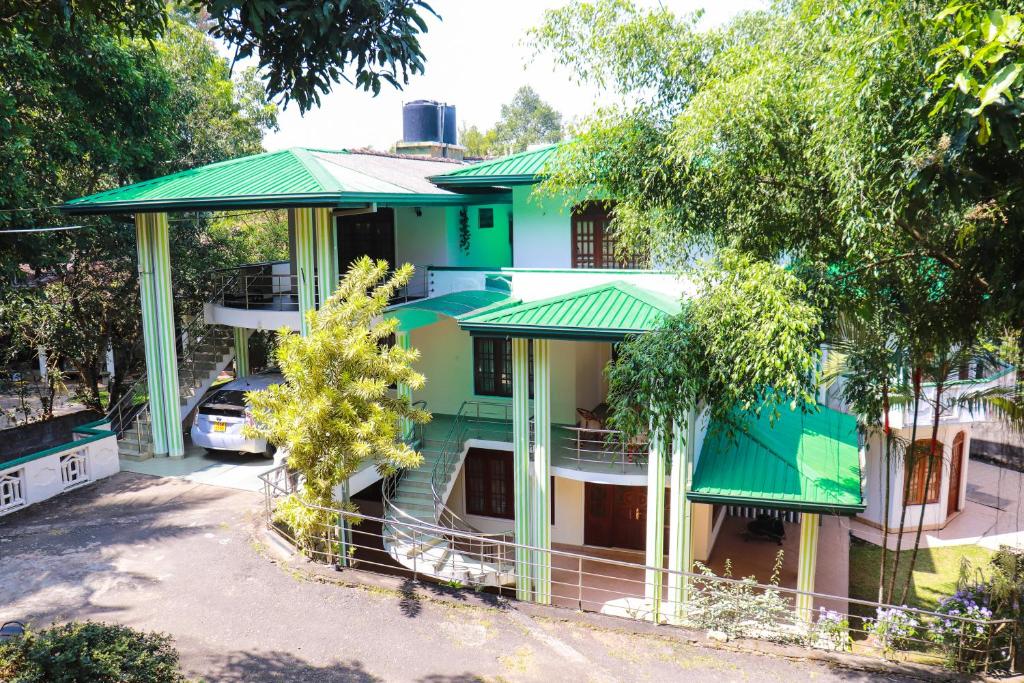 a green house with a green roof at Kandy downtown villa Monza in Bahirawakanda