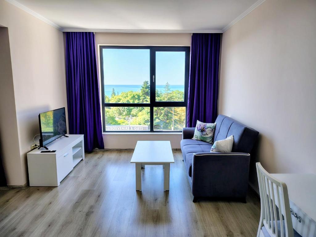 a living room with a couch and a table at Апартамент Ивела in Balchik