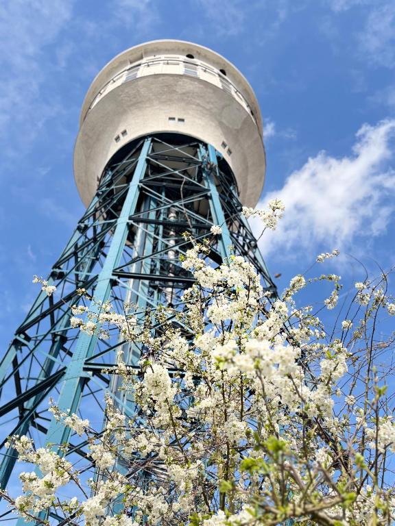a tower with white flowers in front of a tree at Studio Watertoren in Goes