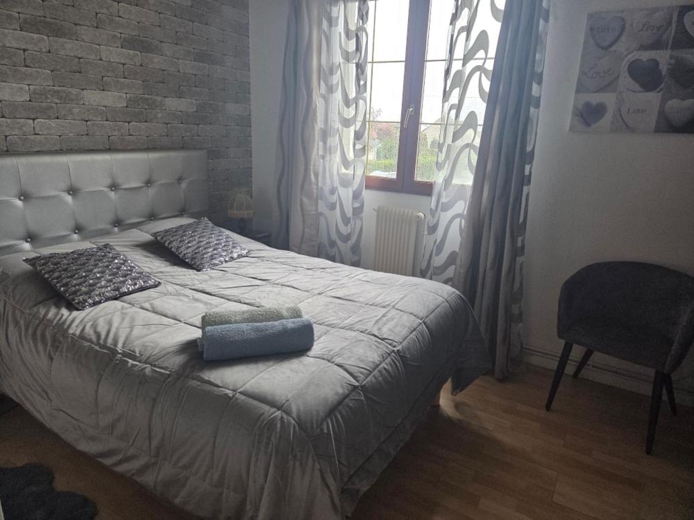 a bed in a bedroom with a brick wall at Jardin Floral in Marquise