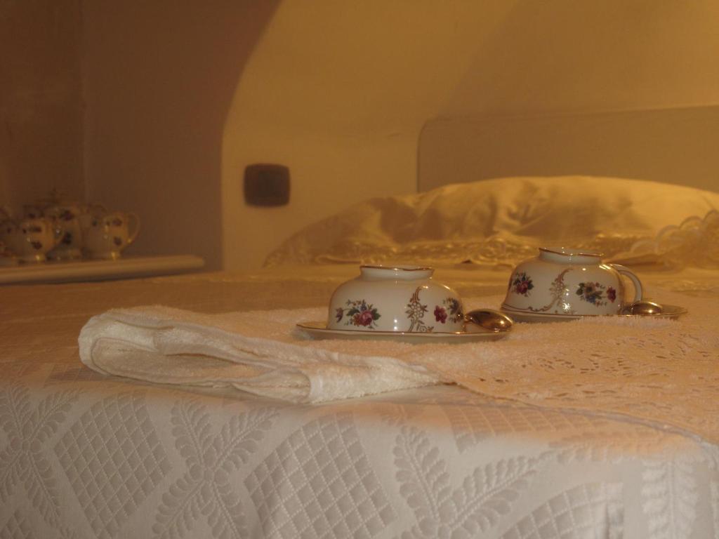 zwei Teetassen auf einem Teller auf einem Bett in der Unterkunft Marilyn in Laterza