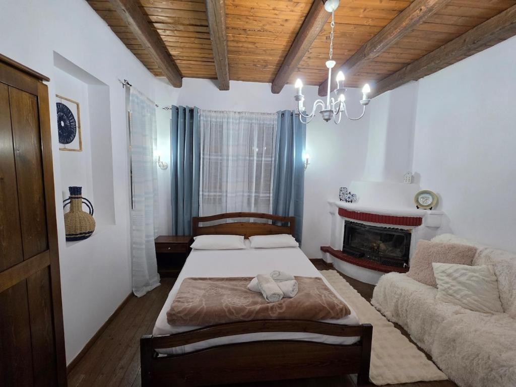 a bedroom with a bed and a couch and a fireplace at Olympia Cozy House in Palaios Panteleimonas