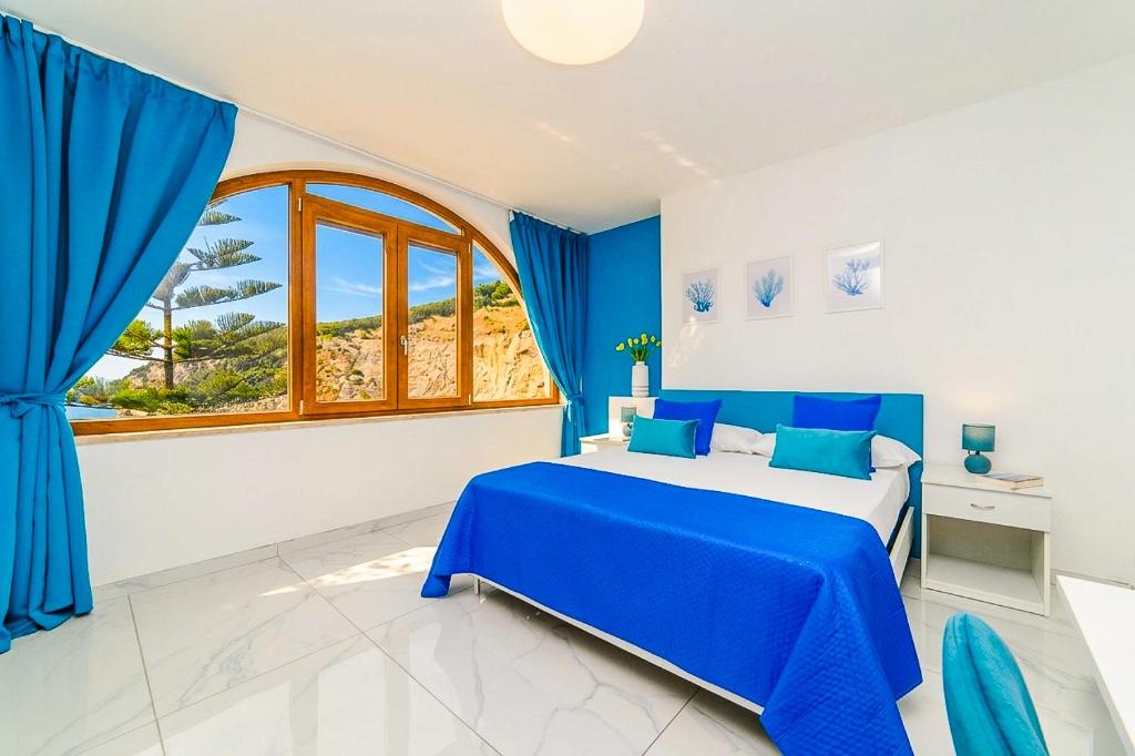 a blue and white bedroom with a bed and a window at Estate4home - Suites Margar in Massa Lubrense