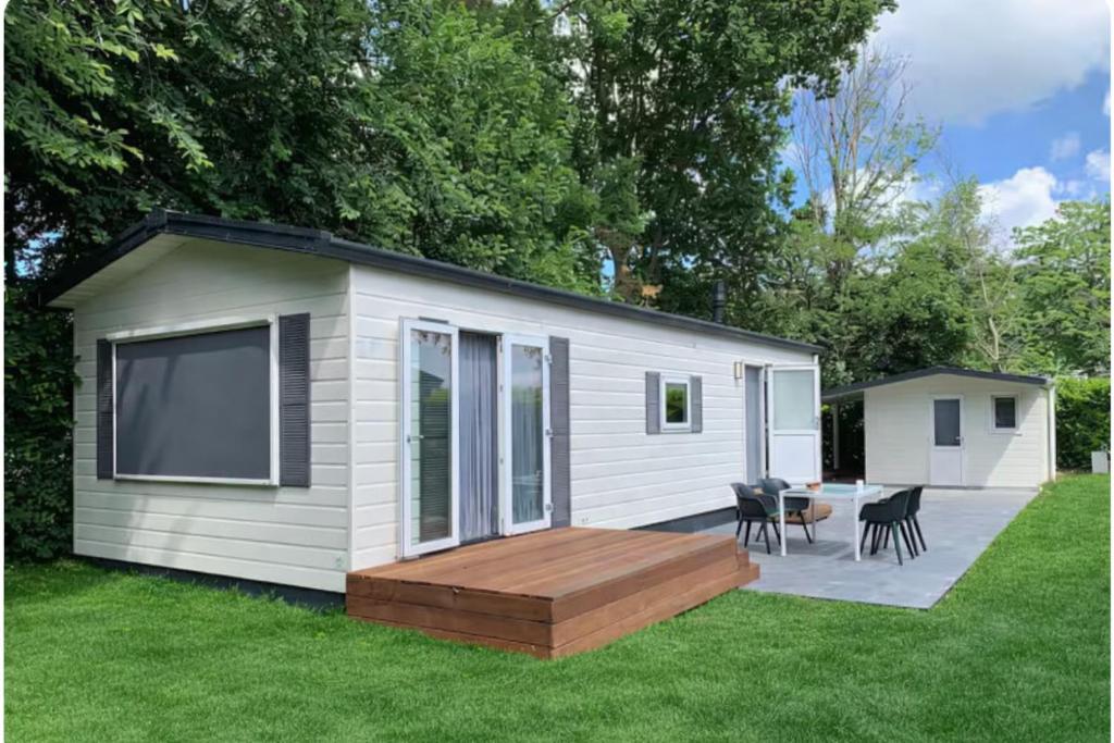 a tiny house with a deck and a patio at 't Vrolijke Uusje in Scharendijke