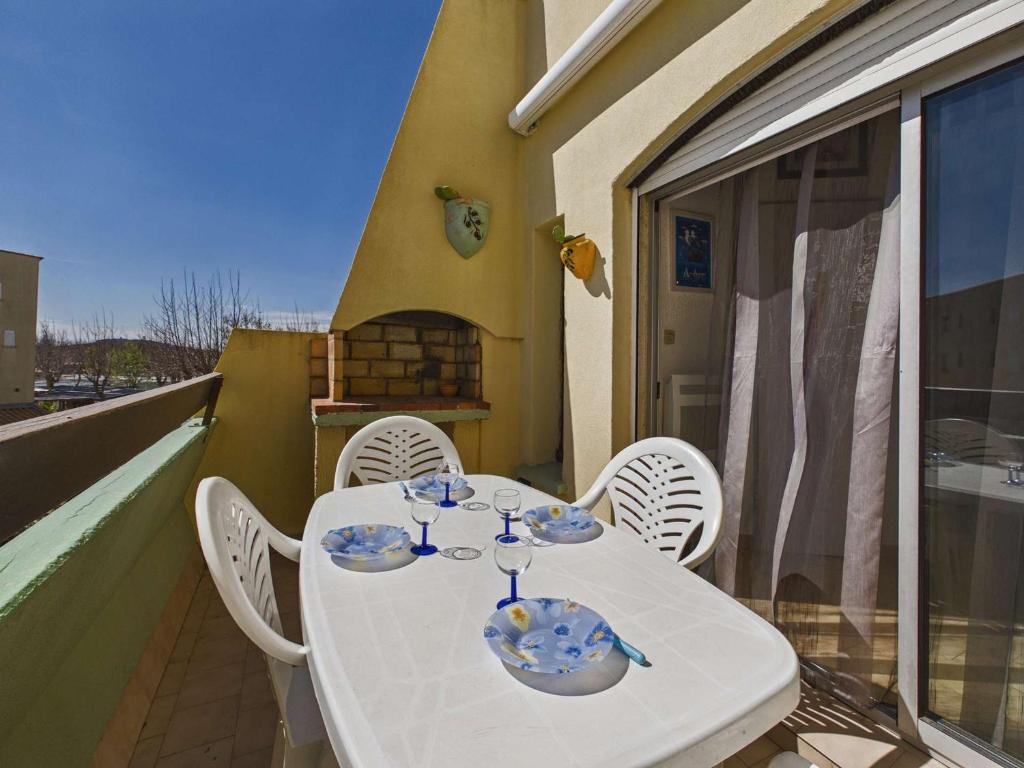 a white table and chairs on a balcony at Studio cabine mezzanine 6 pers avec parking privé - FR-1-326-403 in Marseillan