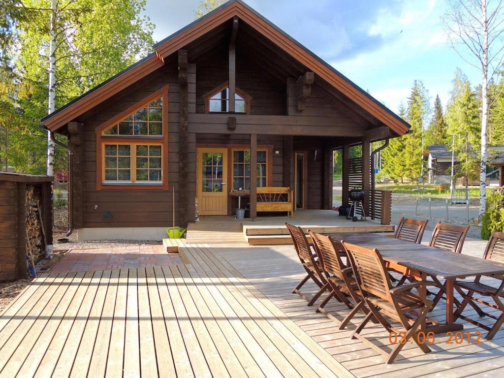 a log cabin with a wooden table and chairs at Villa Nuttu - Loppusiivous kuuluu hintaan in Jämsä