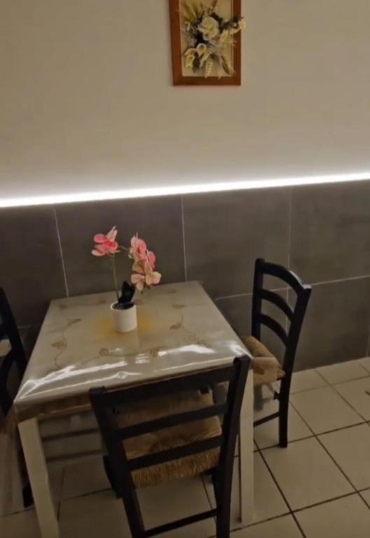 a table with two chairs and a table with flowers on it at Nonna Ninetta - Locazione Turistica in Orta Nova