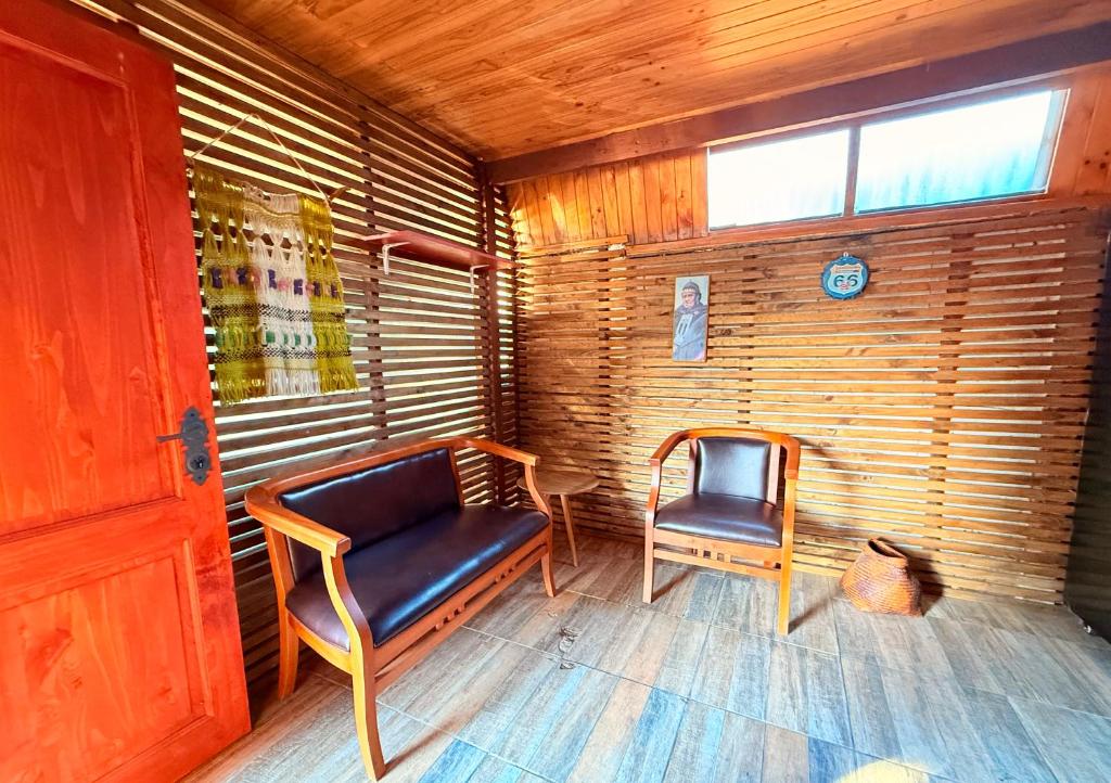 a small room with two chairs and a window at Hospedaje Amore per il lago in Villarrica