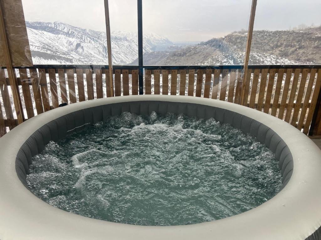 a hot tub on a balcony with snow covered mountains at Bardzunq Garden Resort in Goghtʼ