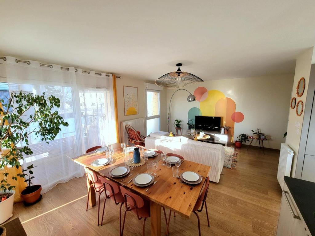 a living room with a table and a dining room at Appartement lumineux proche Genève et Jura 3 chambres, terrasses et parking in Gex