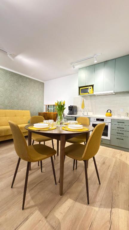 a dining room with a table and chairs in a kitchen at APARTAMENT Nowoczesny PRL in Bydgoszcz