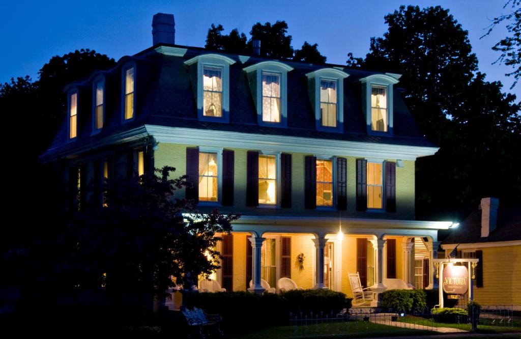 una casa azul con sus luces encendidas por la noche en Inn Victoria, en Chester