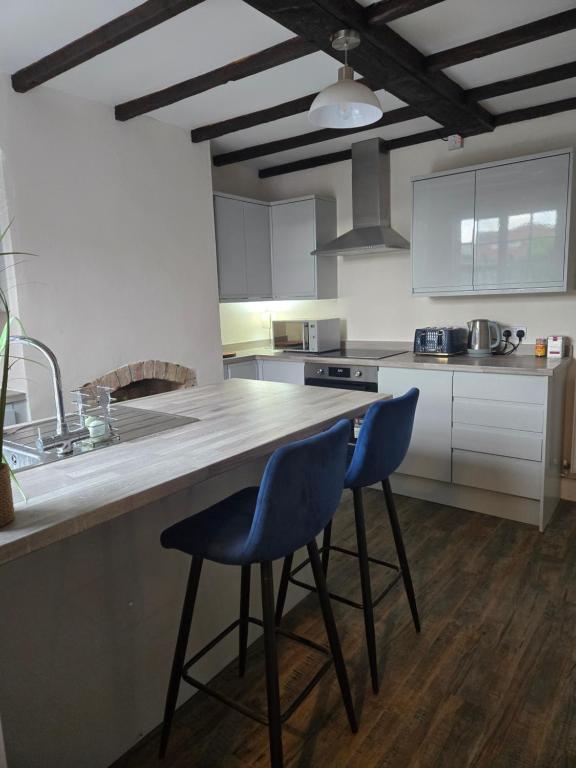 a kitchen with two blue chairs sitting at a counter at The Indigo Escape in Ibstock