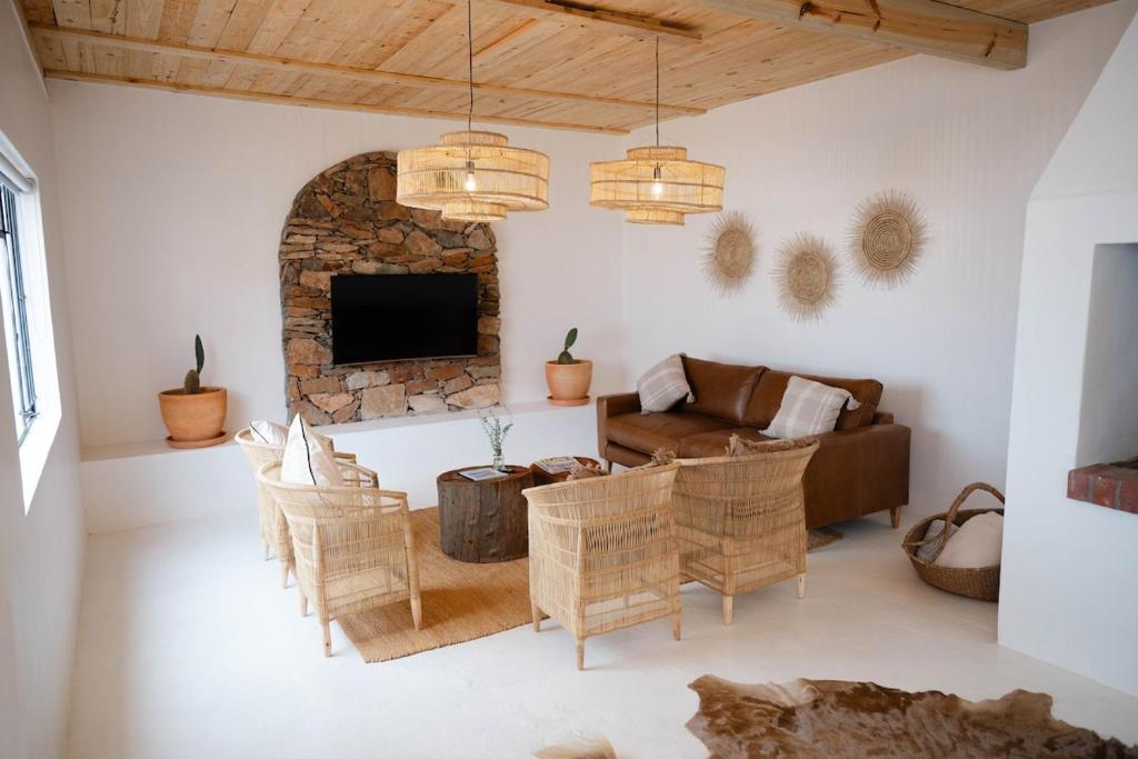 a living room with a couch and chairs and a tv at Landskap in Robertson