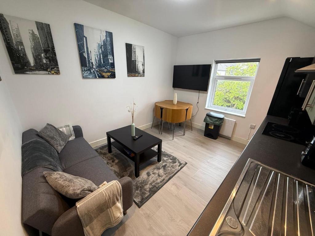 a living room with a couch and a tv at Sleek 1BR Flat Perfect Getaway For Contractors Or Couples in Cardiff