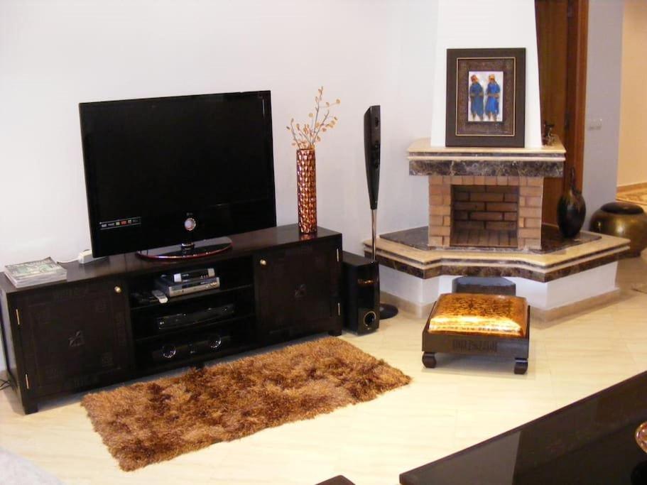 a living room with a flat screen tv and a fireplace at Apartment Hamria Meknes in Meknès