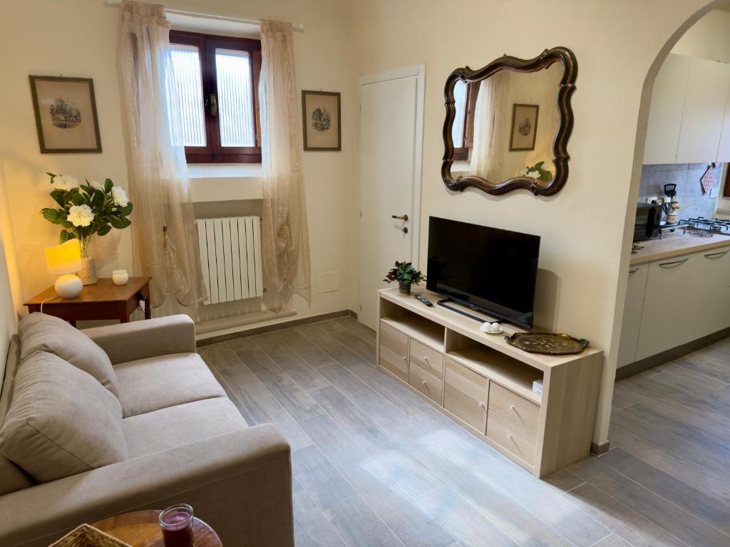 a living room with a couch and a flat screen tv at Casa Falconcini in Volterra