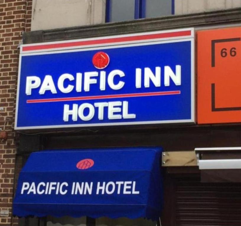 a sign for a specific inn hotel on the side of a building at Pacific Inn London Heathrow in Southall
